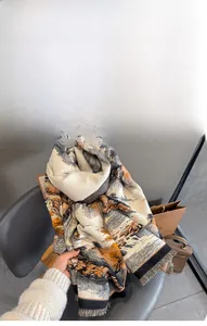 Dettaglio macro delle morbide frange e del tessuto in finto cashmere di questa sciarpa