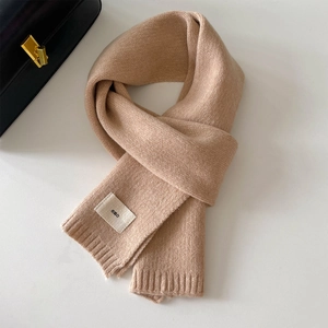 Dettaglio sciarpa in maglia beige con morbida trama cachemire ed etichetta logo