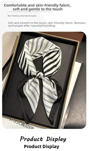 Close-up of black and white striped silk scarf on a premium display tray