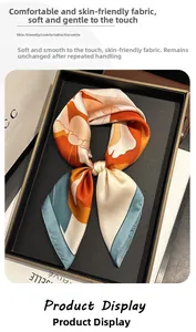 Détail d'un foulard en soie avec imprimé floral abstrait orange et bleu et bords roulés