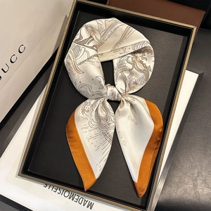 Detailed view of lightweight silk-like scarf with celestial prints and orange edges