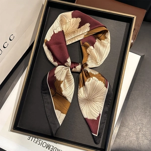 Floral print silk neck scarf in burgundy and gold tied in a bow on a display box