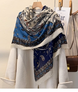 Detail of blue paisley cotton linen scarf featuring frayed edges on a wool coat
