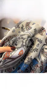 Macro detail of soft paisley cotton linen scarf featuring beige and teal woven patterns