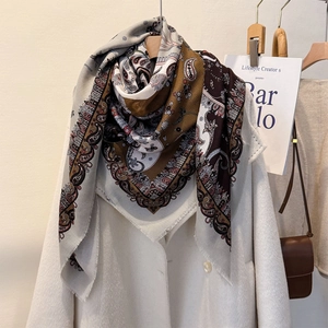 Elegant paisley cotton linen shawl with fringe edges displayed on a white coat
