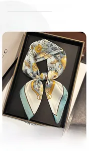 Detail of floral silk scarf with daisy patterns and elegant gold equestrian chain elements