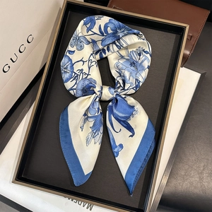 Detail of floral printed square silk scarf with blue lily and butterfly patterns