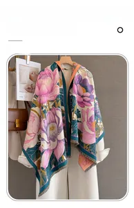 Close-up of floral imitation cashmere scarf with tassels draped on a white wool coat