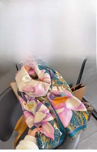 Detail of soft faux cashmere scarf featuring large lotus print and delicate fringe trim