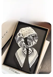 Vue détaillée d'un foulard 70cm en imitation soie à motif paisley noir et blanc sur un plateau