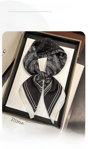 Détail d'un foulard en soie noir et blanc avec motif paisley dans un cadre chic