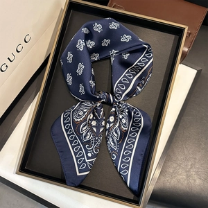 Carré de soie bleu marine à motif cachemire présenté dans un cadre cadeau luxueux