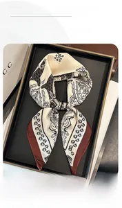 Détail d'un foulard en soie synthétique à motifs paisley en beige et marron café foncé