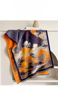 Détail de l'écharpe en jacquard avec motif montagne orange et bordures à fines franges