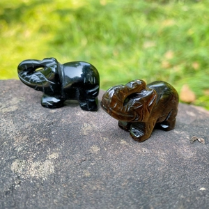 Hand-carved 1.5 inch natural tiger eye and obsidian elephant figurines on stone