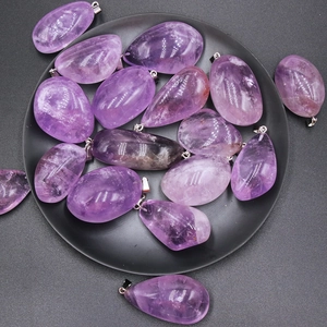 Pendentifs en améthyste naturelle de formes variées sur un plateau sombre
