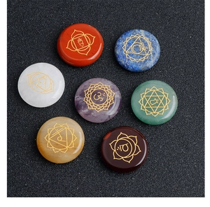 Macro view of seven polished chakra stones with golden engraved sacred symbols