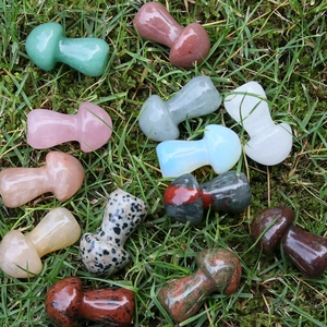 Verschiedene Mini-Pilzfiguren aus Naturkristall und Edelstein auf grünem Moosgrund