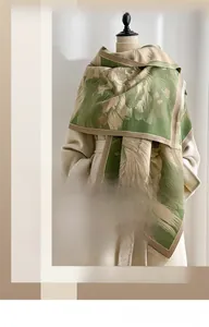 Detail of green floral jacquard winter scarf showing premium texture and frayed edges
