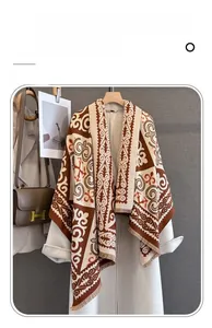 Detail of imitation cashmere scarf with ethnic pattern and fringe on white coat