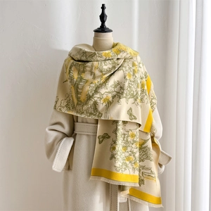Close-up of winter landscape print scarf with floral patterns and yellow borders