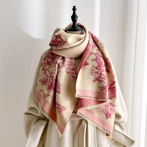 Detail of cashmere-like scarf showing vintage red floral patterns and tassel edges