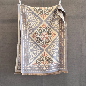 Detailed close-up of bohemian geometric jacquard patterns and fringe on a thick winter scarf