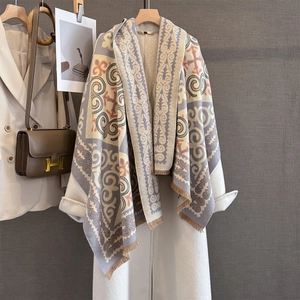 Close-up of vintage geometric pattern shawl with tassels on a white wool coat