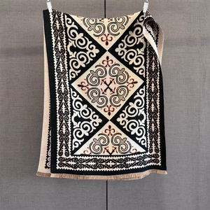 Detail of geometric ethnic pattern on thick winter shawl with fringe decorations