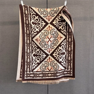 Close-up of geometric jacquard knit pattern with tassels on vintage ethnic shawl