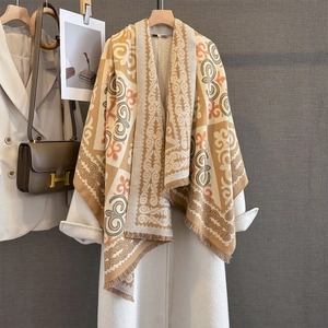 Close-up of vintage geometric jacquard scarf with tassels on a white coat