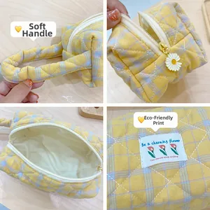 Detail of yellow checkered quilted tote showing soft handles and daisy zipper head