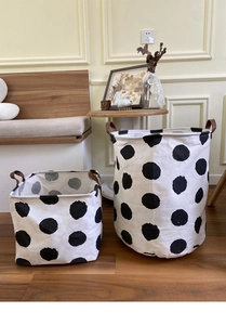 Close-up of canvas storage baskets with black polka dots and leather handles set