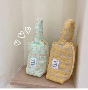 Detail of quilted cotton toiletry bags with colorful grid patterns and zip closure