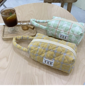 Detail view of quilted cotton makeup bags in yellow and green with tulip patches
