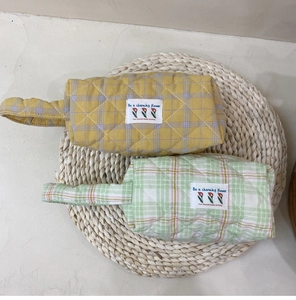 Detail of quilted plaid cotton bags with woven straps and charming flower fabric labels
