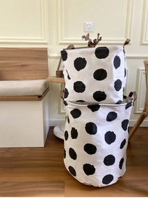 Detail view of canvas storage baskets with black polka dots and brown leather handles