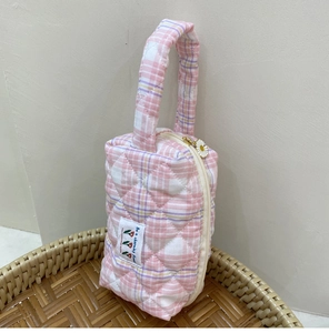 Detailed macro view of quilted cotton checkered handbag with daisy zipper and fabric label