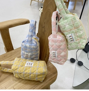 Quilted cotton makeup bags in candy colors with top handles and floral fabric labels