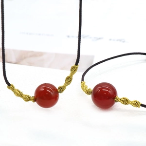 Natural red agate bead pendant on a minimalist dark cord with gold braided accents