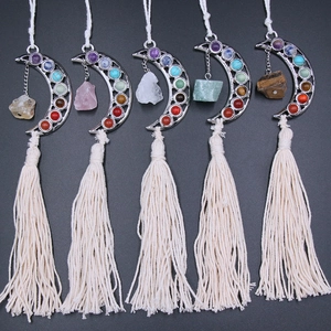 Five-piece bohemian moon-shaped chakra stone pendants with cotton tassels on gray background