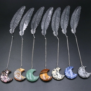 Silver metal feather bookmarks with seven natural crystal moon pendants on dark background