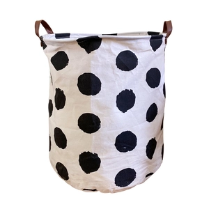 Minimalist black and white polka dot laundry basket with leather handles in a foldable design