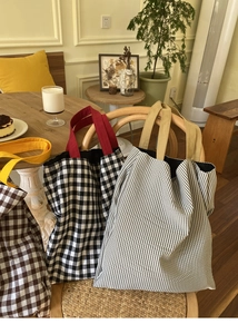 Gros plan détaillé de sacs cabas en toile à rayures et à carreaux sur une chaise