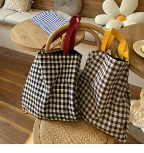 Détail des sacs fourre-tout en toile à carreaux avec poignées colorées en décor maison