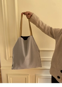 Détail du grand sac cabas en toile rayée avec des poignées marron texturées