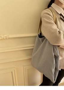 Détail du sac fourre-tout en toile rayée bleue avec bandoulières kaki et grande capacité