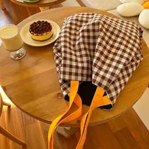 Grand sac cabas en toile à carreaux avec anses orange sur table en bois