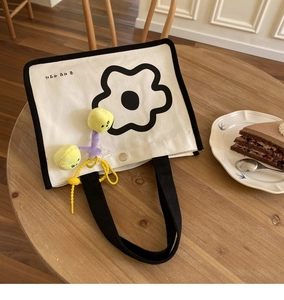 Détail du sac à lunch en toile avec imprimé floral et fermoir magnétique en métal