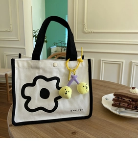 Détail du sac à lunch en toile avec imprimé floral, bouton pression et cerise